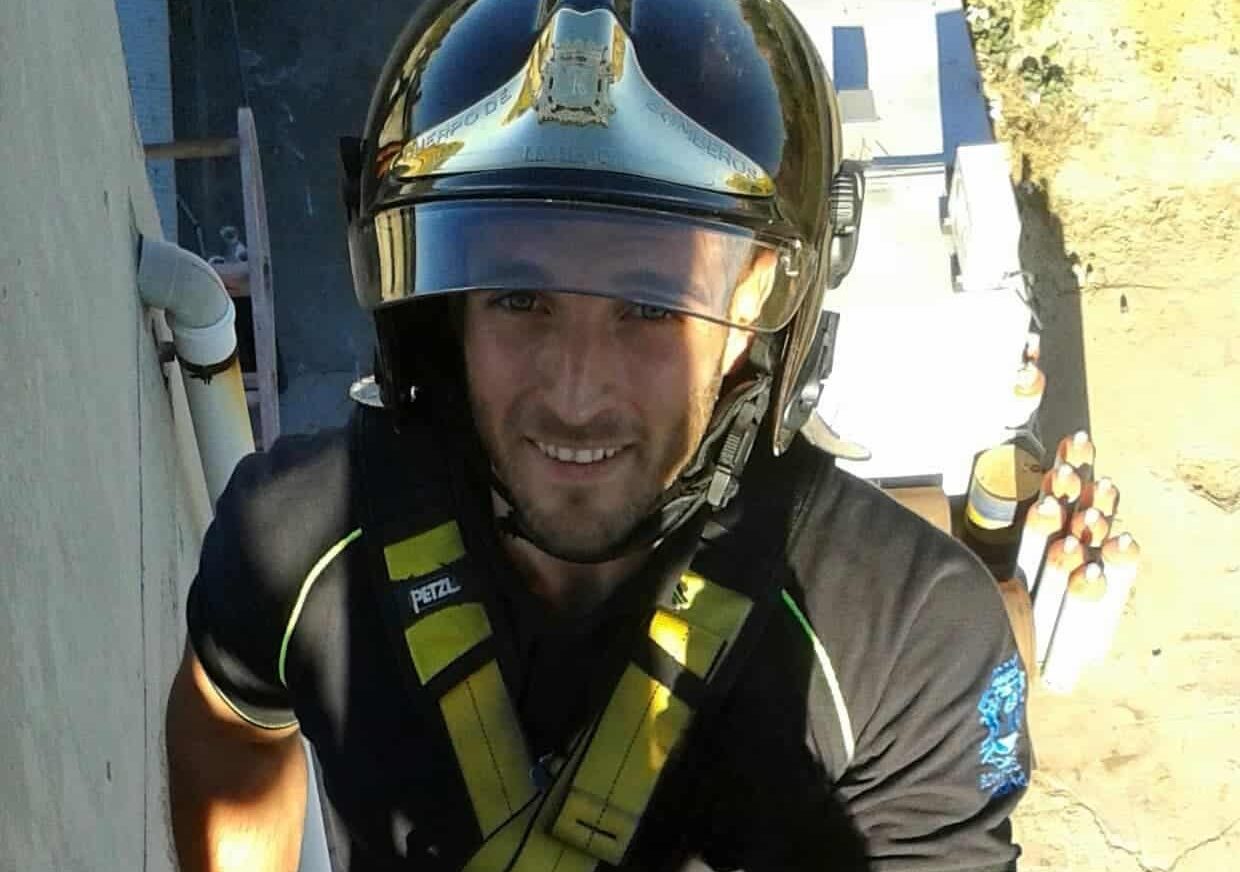 Inicio 3 Bombero en entrenamiento con casco dorado y arnés, símbolo de concentración y precisión profesional.