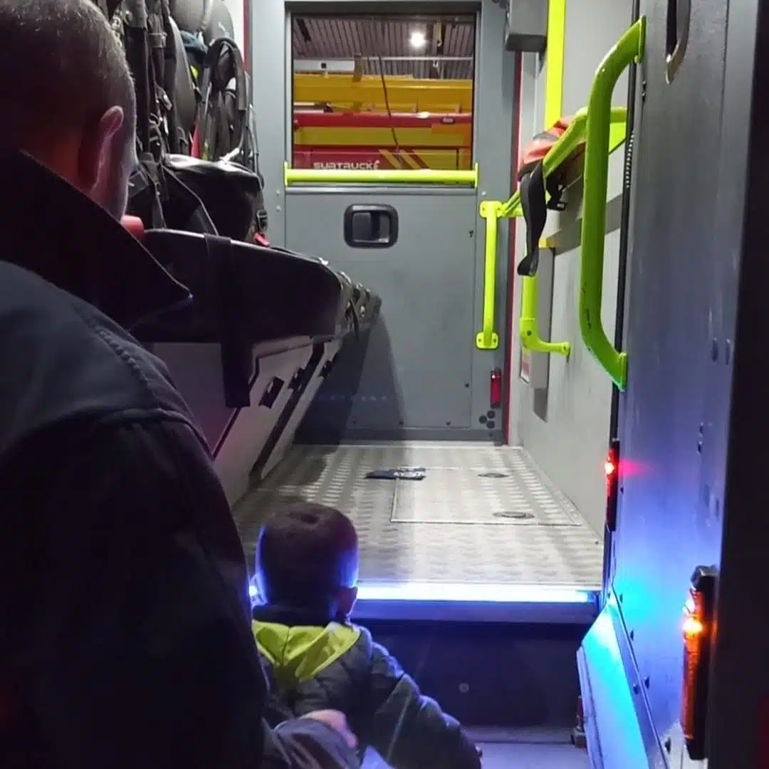 Inicio 6 Niño y adulto observan con curiosidad el interior iluminado de una ambulancia moderna.